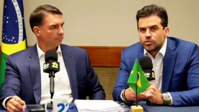Após debate cancelado, Flávio Bolsonaro culpa Lula por 'interferência judicial', improvisa live com aliados e faz campanha por voto útil