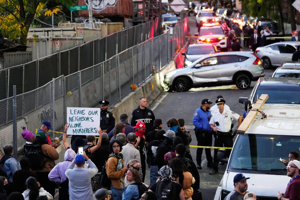 People gather at the scene of a shooting as law enforcement work the area Thursday, Oct. 8, 2026, in New York. (AP Photo/Seth Wenig)