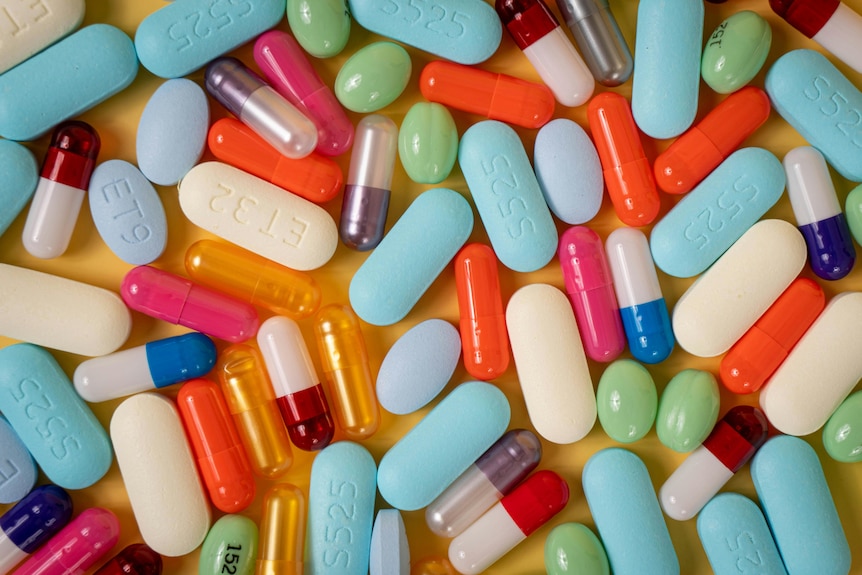 A pile of drugs on a table, all are different shapes and sizes.