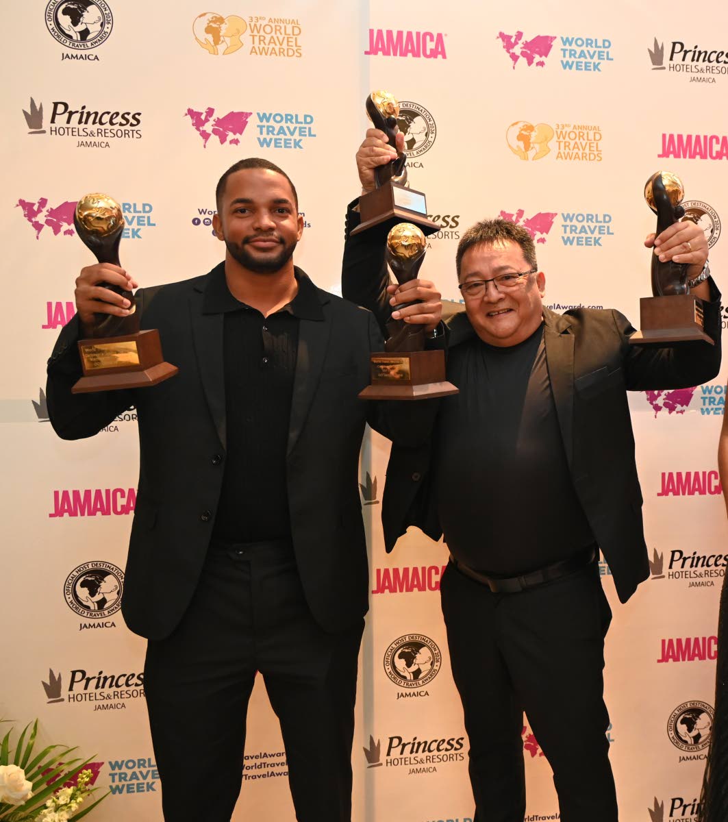 GO! Jamaica Travel’s Javier Montero (left) and CEO Dave Chin Tung hoist their four awards.